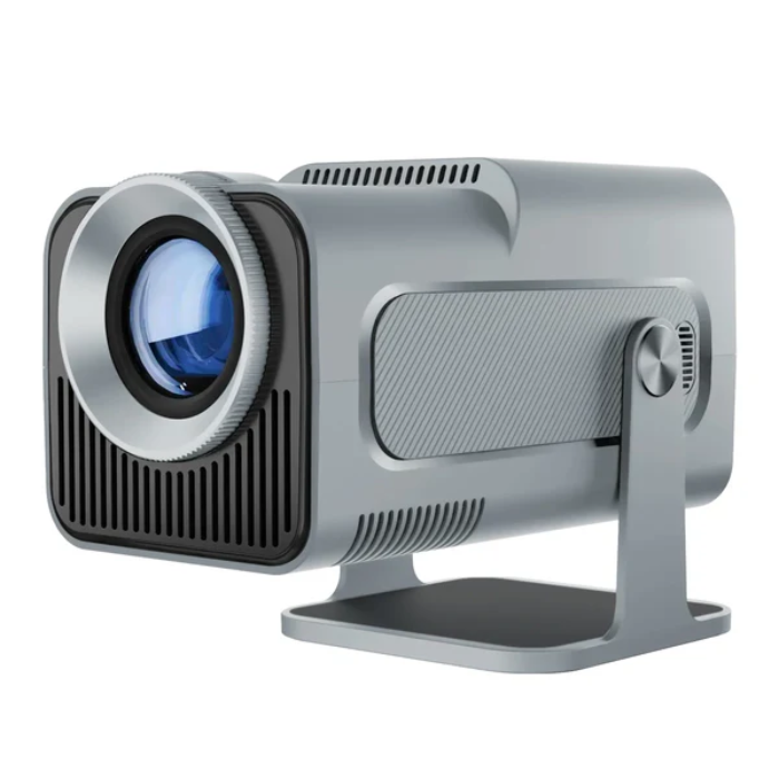 HY320 mini projector next to a 13‑inch laptop to illustrate its compact portable size.