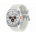 Lifestyle flat‑lay of Galaxy Watch Ultra Titanium White next to smartphone, sunglasses and trail map.