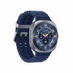 Samsung Watch Ultra 47mm Titanium Grey placed next to a compass and topo map on a wooden table.